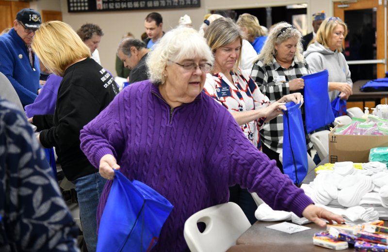 Audrey Schaeffer of the Women of Sussex County group fills a bag for the at-risk vets.
