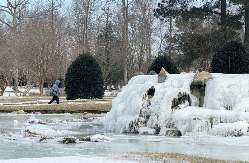 A Baywood employee walks past the frozen waterfall on the way into the clubhouse.