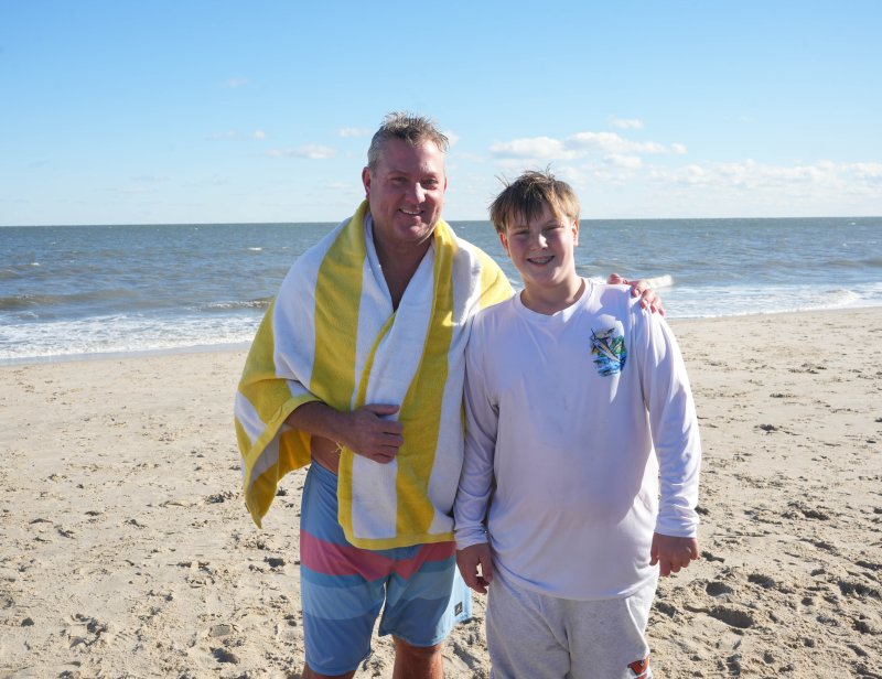 Peter Wintermute, left, and his son, Carson, try to get dry and warm up after the Dewey Dunk.