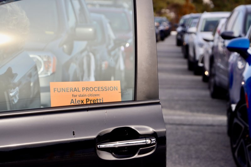 A funeral procession sign is displayed on the window of a car in line at the Cape May-Lewes Ferry Terminal in Lewes. BILL SHULL PHOTOS