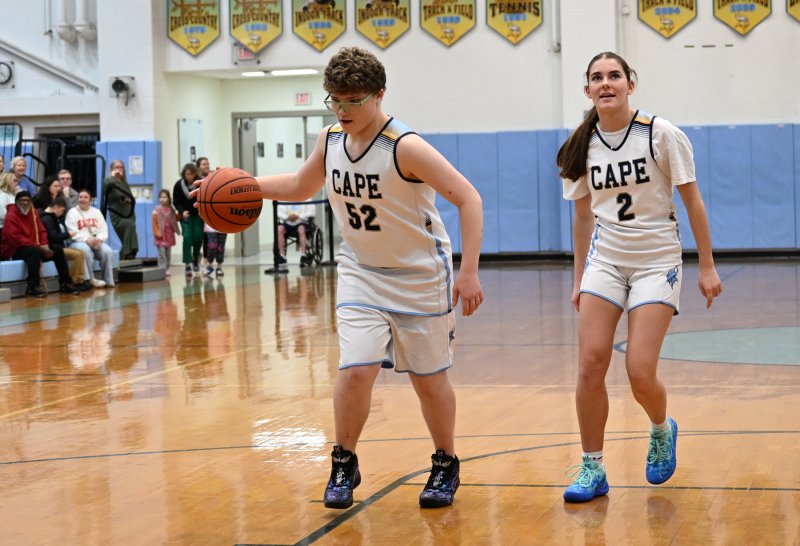 Cape junior Robert Harman-Strike drives to the bucket with an assist from junior unified partner Camilla Willis.