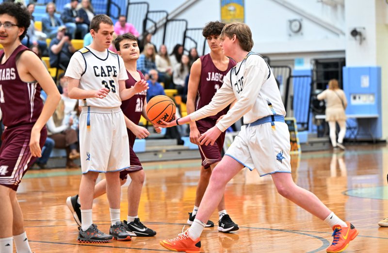 Cape unified partner Erichson McMahon, right, gets an assist with senior Dan Gartman.