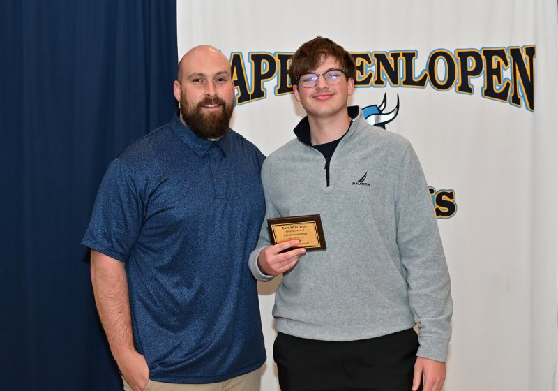 Wide receiver coach Zachary Horstmyer presents the Legends Award to senior Braden Wiswall.
