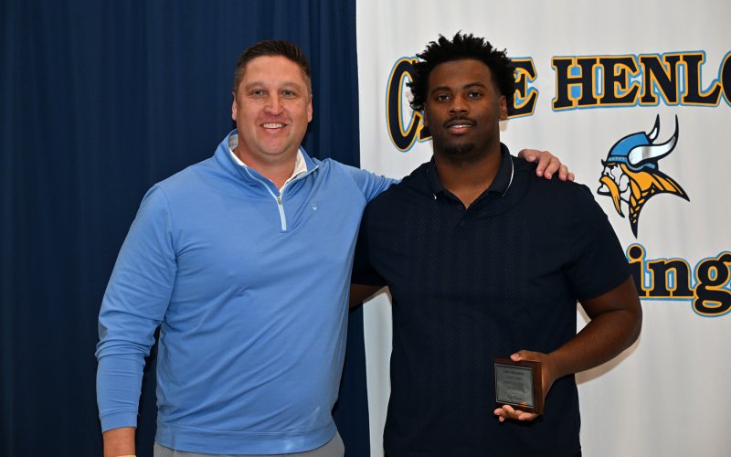 Varsity assistant coach Jason Pease presents the Captain Award to Trey Batson.