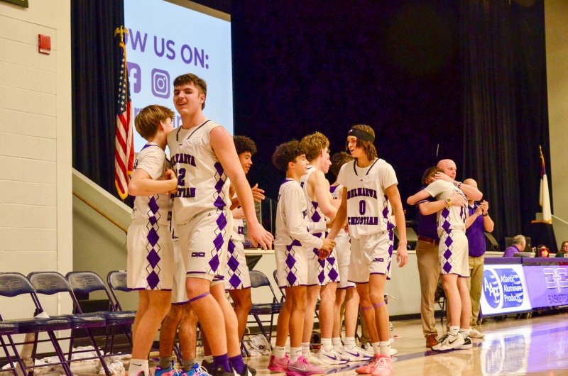 Seniors Andrew Collins, left, Seth Mifflin, center and Gideon Woods receive their props from their teammates and coaches after being subbed out for the final time in their high school careers.