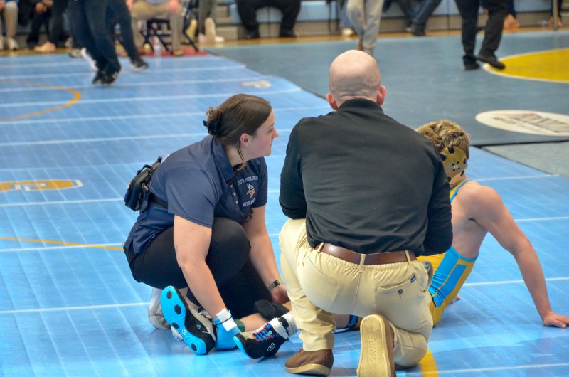 Hollyann Wettstein works on Cape wrestler Blake Walker during the second day of the DIAA individual wrestling tournament.