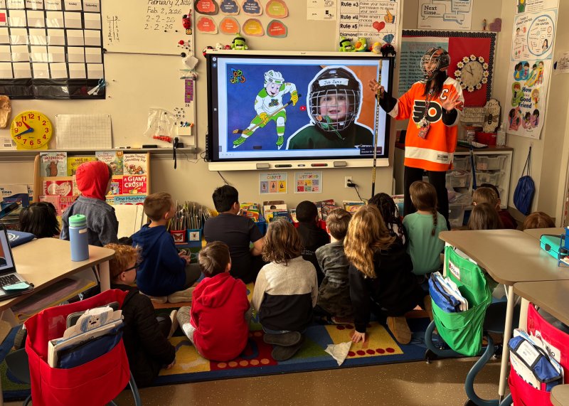 Second-grade teacher Olga Tigue presents information about ice hockey.
