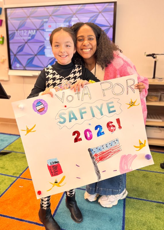 Candidate Safiye Tan, left, shows off her presidential campaign poster with help from Elizabeth Núñez.