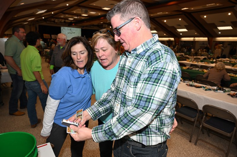Guy Wiggins, right, buys some pull tags chances from Kathy Dougherty and Cindy Lukenda.