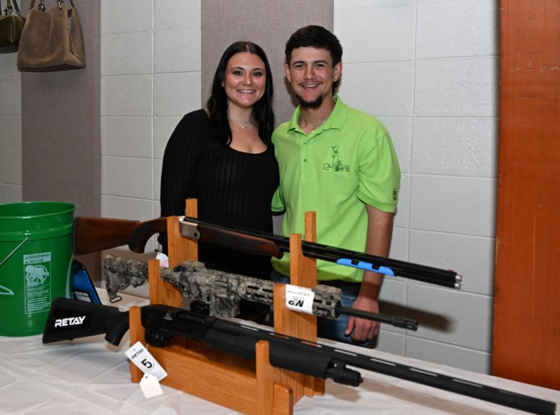 Natalie Buckman and Cole Fluharty work the small guns table.