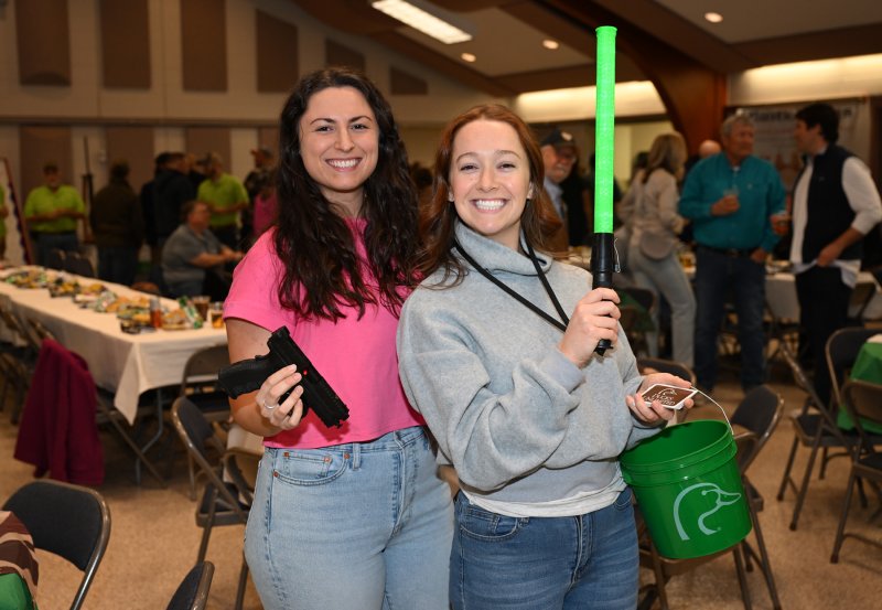 Tori Sebastian, left, and Serena Hughes sell chances at the gun wall.