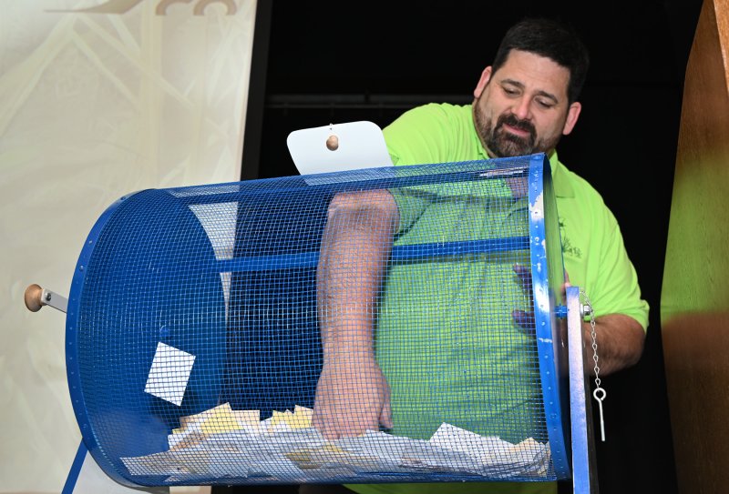 Don Don Mitchell picks a gun winner from the many tickets in the rotating raffle drum.