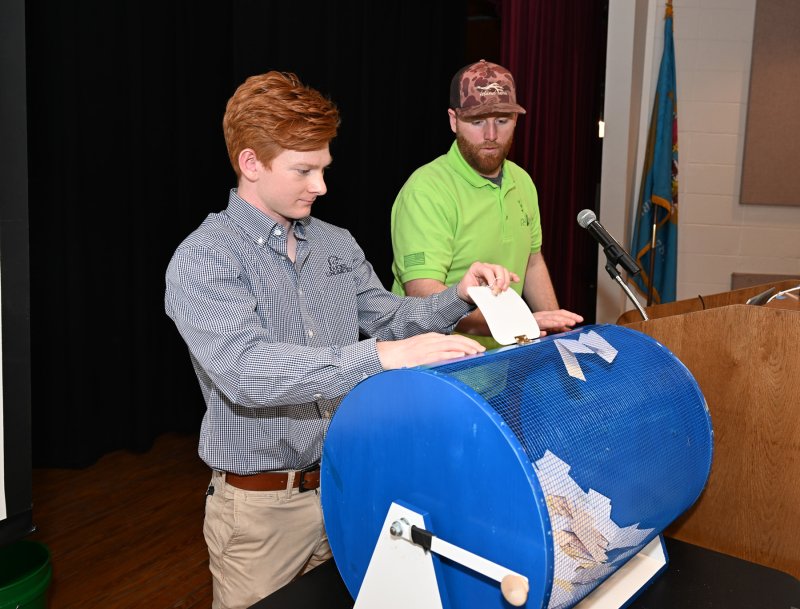 Jack Morris, left, and Michael Bateman draw names from the rotating raffle drum.