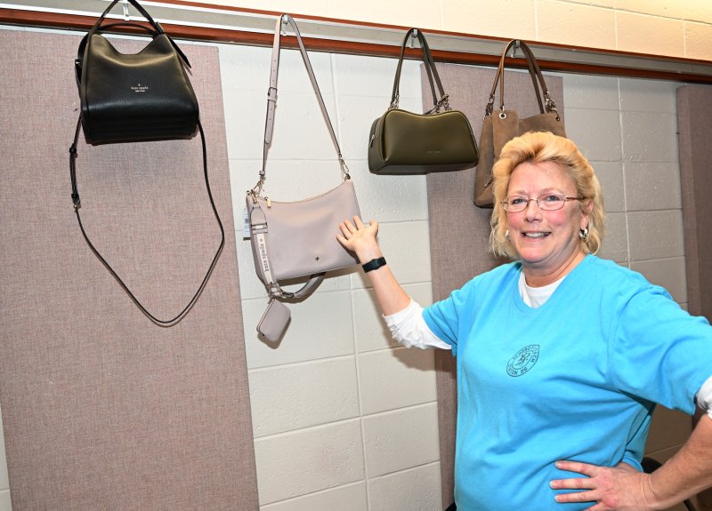 RBVFC Auxiliary member Mary Backstrom does her best Vanna White impression at the designer pocketbook wall.