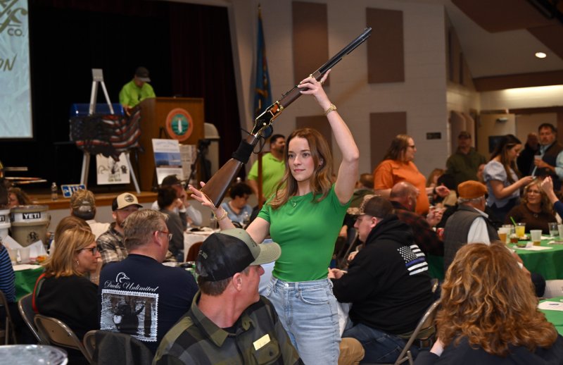 Ashley Lyons displays the Gunbash Custom Henry Golden Boy .22 long rifle up for auction.