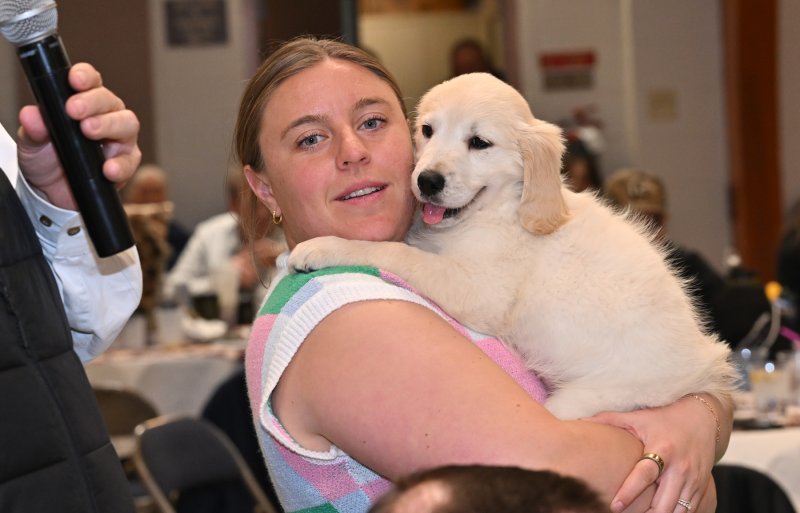 Volunteer Lynsy Oronzio gives some last-minute love to the second puppy.