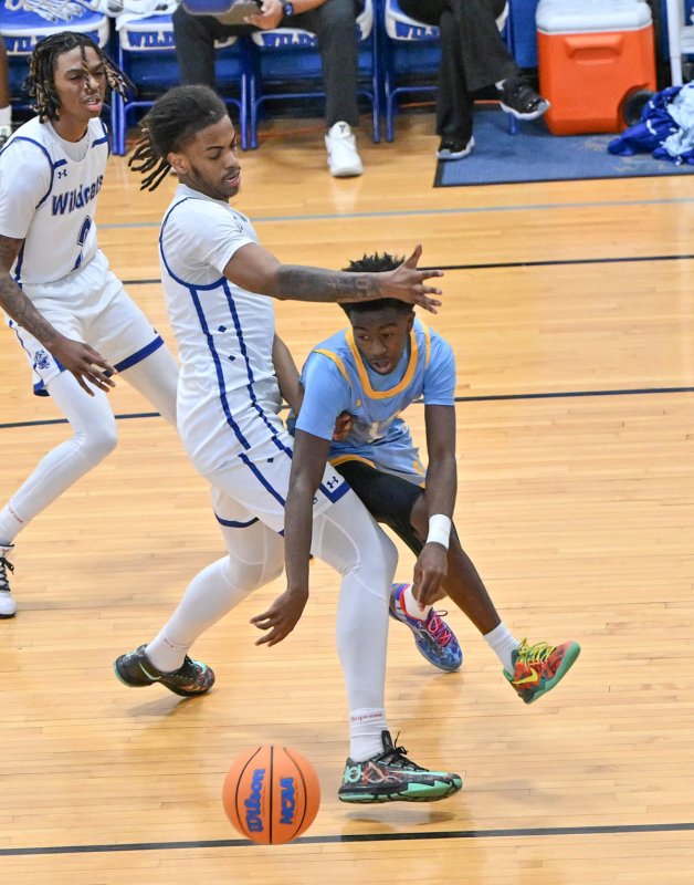 Cape junior point guard Stephen Sivels passes to the paint around Howard’s Dominic Awahmukalah.