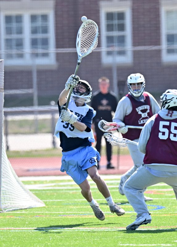 Cape goalie Mason Trench gets major air to coral a loose ball.