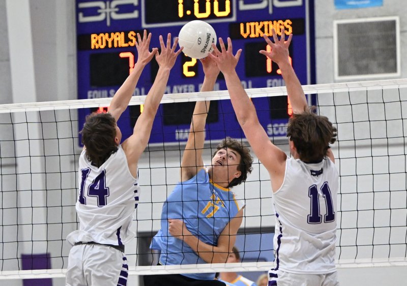 Cape senior Blake Fitzgerald slams a kill through the block attempt of Delmarva Christian’s Henry Ennis, left, and Jack Rodgers. DAN COOK PHOTOS