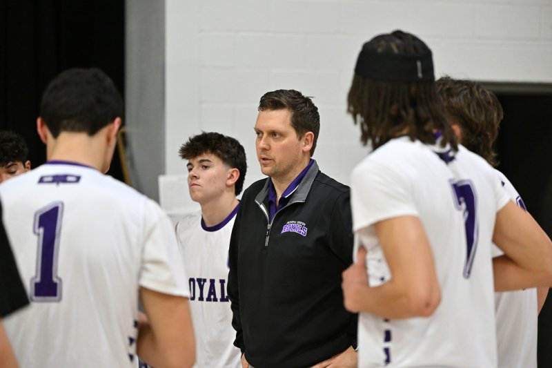 Royals coach Ryan Kaufmann speaks with his team during a third-set time-out.