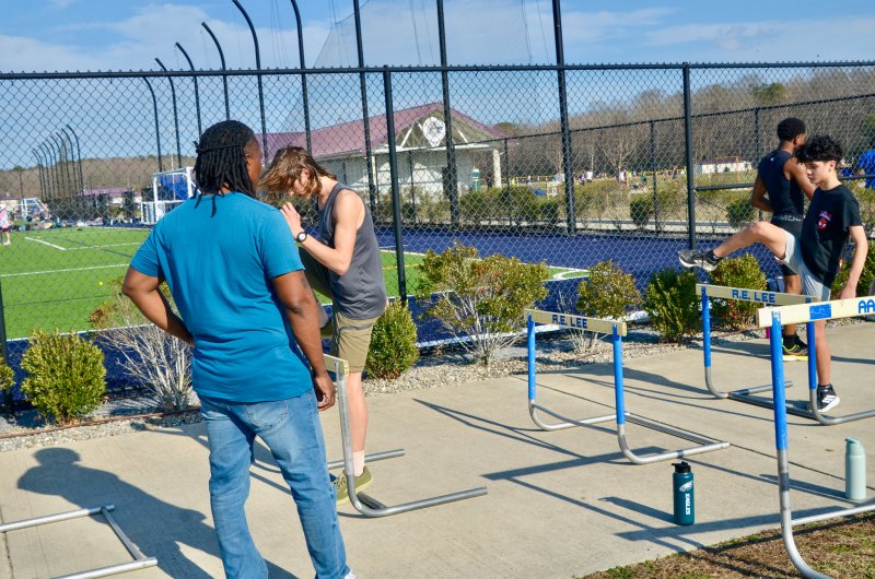 Sussex Academy coach Shawn Hopkins watches senior Aiden Zook, left, and eighth-grader Damian Lucero-Sandoval work on their form.