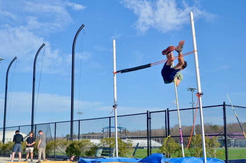 Sussex Academy sophomore Owen Laux pole vaults over the bands.