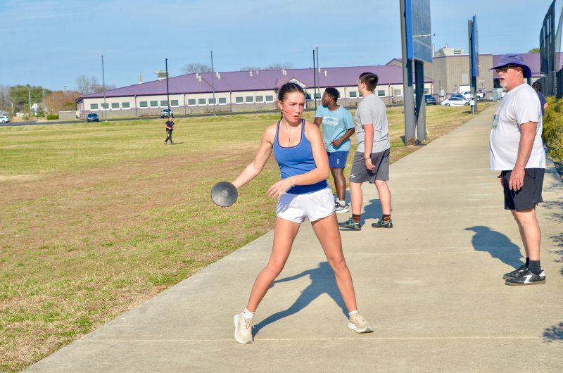 Seahawks junior Layla Hastings throws the disc as coach BK Kennedy looks on.