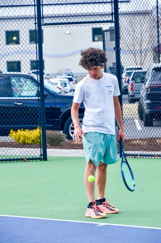 Sussex Academy senior Logan Mattie bounces the ball before a serve.