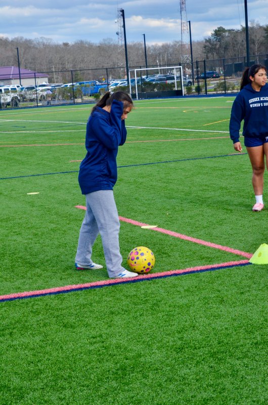 Sussex Academy freshman Paty Lara-Nieto covers her ears for warmth on a late winter day.