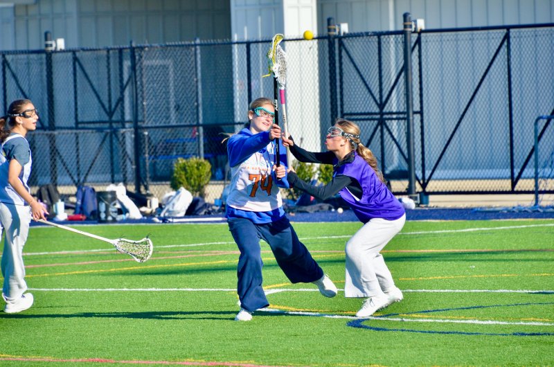 Seahawks junior Liz Layton feeds the ball as sophomore Logan Stiles gets in on her hands.