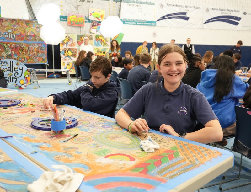 Gannon Olewiler, left, and Curlett Walsh join the other students warming up for the creative exercise by doodling on a table.