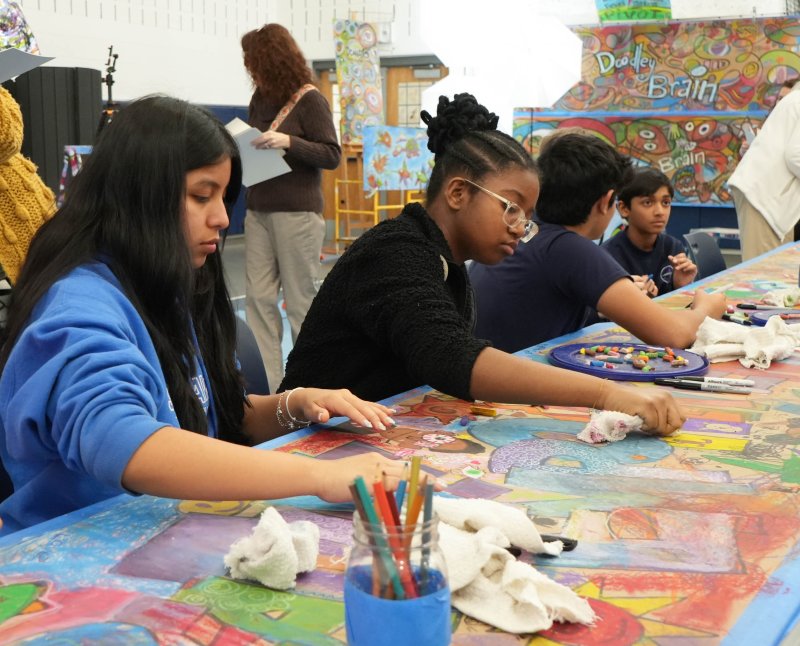 Students Dayana Solis-Velasquez, left, and Sahima Paul use pastels to doodle on the table during a creative warmup.