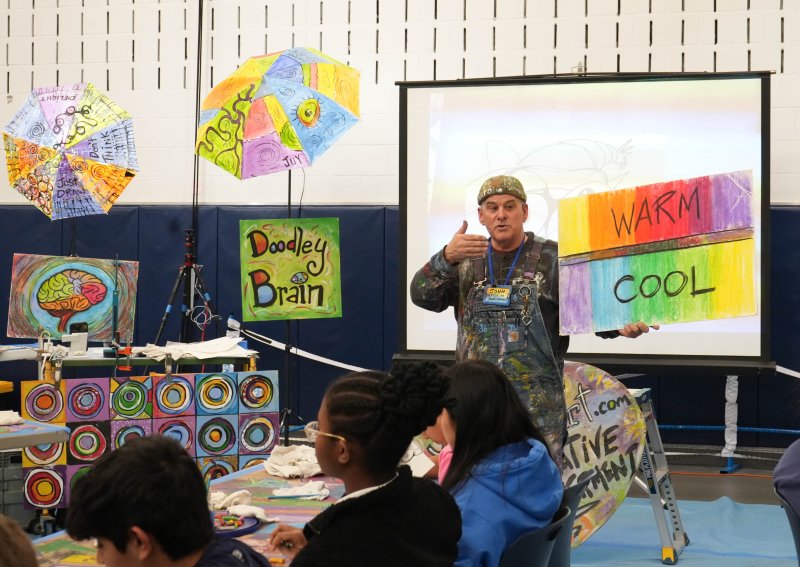 John Donato explains that he has red-green colorblindness and thus does not like using the color wheel because the colors blend together. Instead, he looks at warm and cool color families and likes to pair opposite colors together in his artwork to really make it pop and make bold distinctions between the colors.