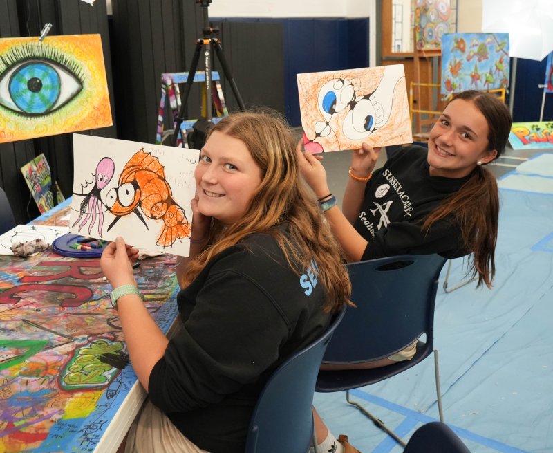 Emily Painter, left, and Garrity Cox proudly hold up their artwork.