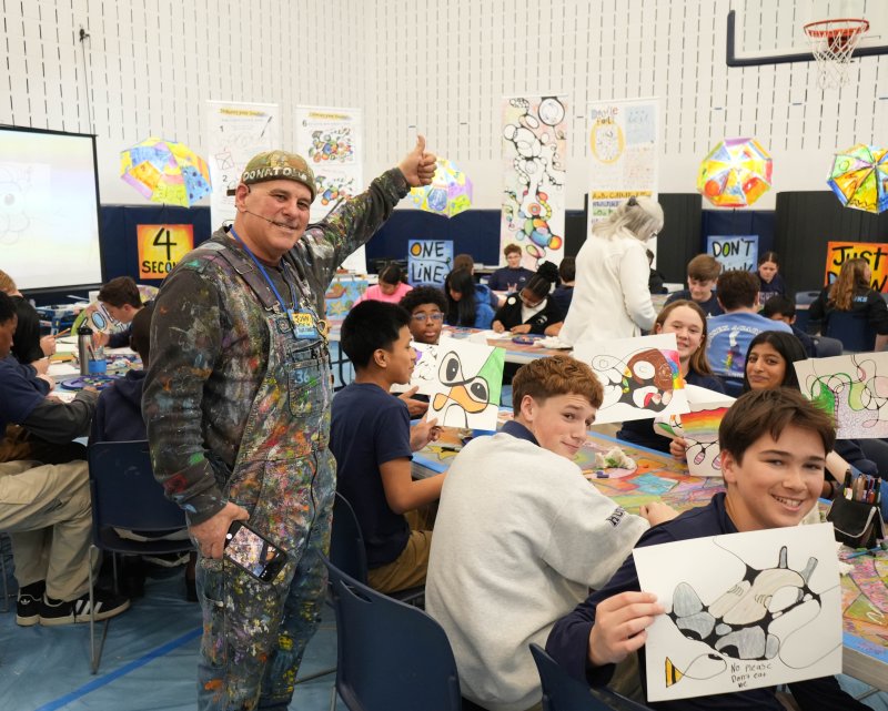 Local artist John Donato, left, known to the kids as Mr. Messy, leads a creative art lesson with Sussex Academy eighth-graders March 13. Shown, starting with students in the back row at the table, are (l-r) Brandon Wilkinson, Jillian Reed and Zoey Shenoy. In front are Alec Perez-Sanchez, Ethan Marsch and Finley Sherman. ELLEN MCINTYRE PHOTOS