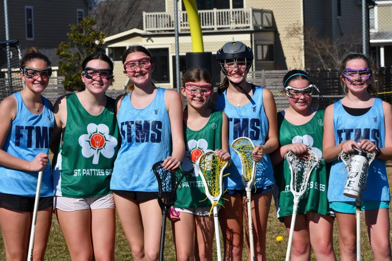 Girls get together at lacrosse practice.