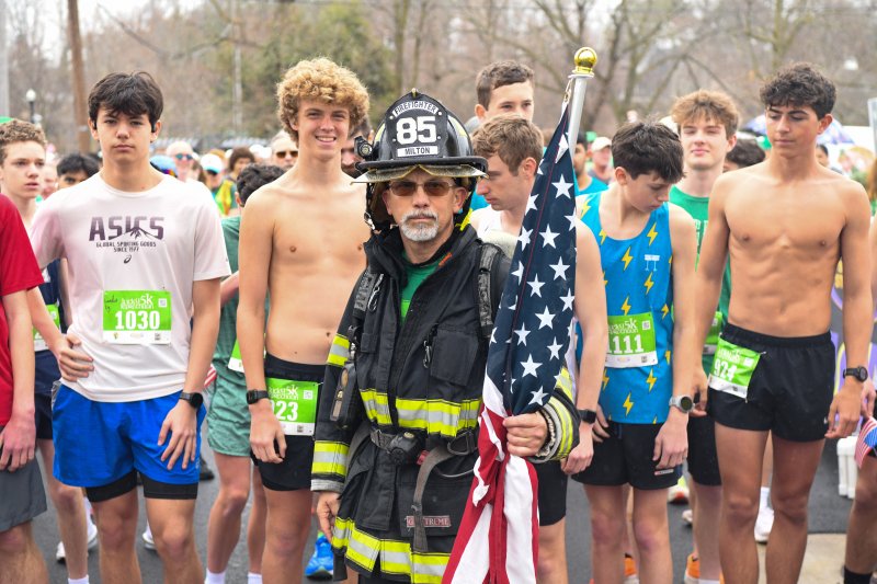 Allen Jackson stands in front of Cape cross country runners at the start of the Lucky Leprechaun 5K in Milton. DAVE FREDERICK PHOTOS