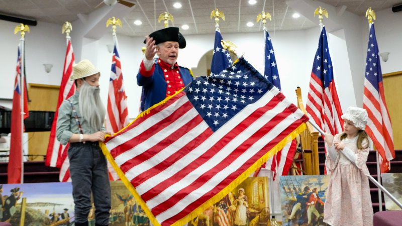 With the assistance of Legacy Academy students Matthew Cooper and Sophia Cooper, Darryl Hudson of the Delaware Society of the Sons of the American Revolution, Caesar Rodney Chapter, delivers a presentation on the history of the American flag. SUBMITTED PHOTOS