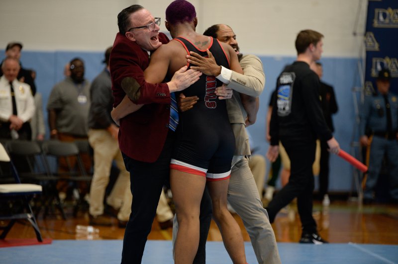 Camar Miller jumps into arm of Joe Archangelo and Bijan Banks.