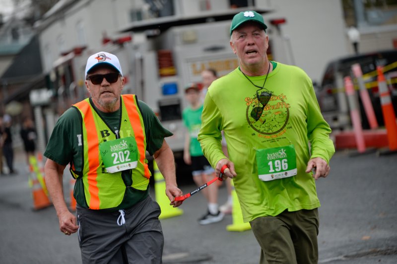 Blind runner Joe Aukward and Tom Holton.