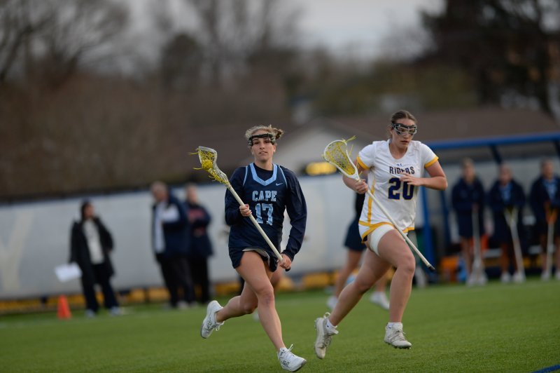 Regan Best, a two-way player, moves through the midfield shadowed by Emily Daddio.