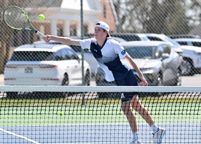 Sussex Academy’s Leo Benz pops a wide volley at first doubles.