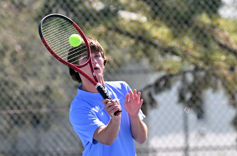 Jackson Hess pops a forehand volley at first doubles.