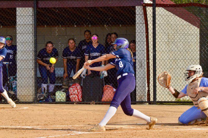 Sussex Academy senior Ryan Lowe watches the ball pop off her bat.