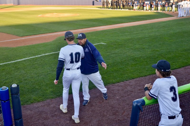 Seahawks coach Mike DiCarlo greets Laine Roberts as he makes his way to the third-base line during player introductions.