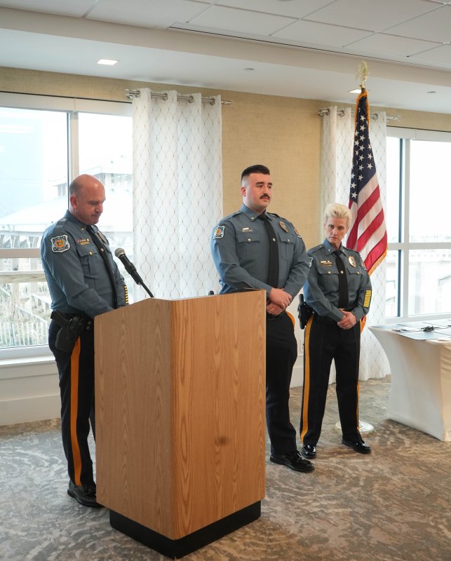 Lt. Cliff Dempsey, left, promotes Adam Ur, middle, from officer to patrolman first class. Also shown is Chief Constance Speake.
