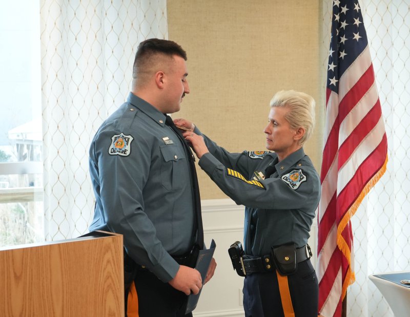 Pfc. Adam Ur, left, receives a new badge from Chief Constance Speake.