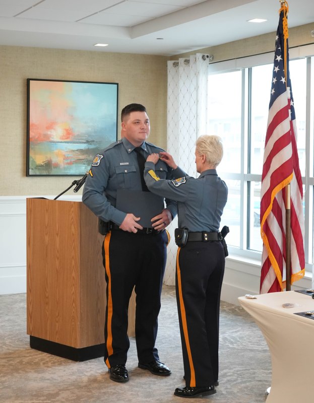 Cpl. James Rieley, left, receives a new badge after being promoted from patrolman first class.
