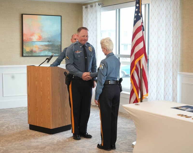 Staff Cpl. Jesse Swanson, middle, shakes Chief Constance Speake’s hand after being promoted from corporal. Lt. Cliff Dempsey, standing behind Swanson, looks on.