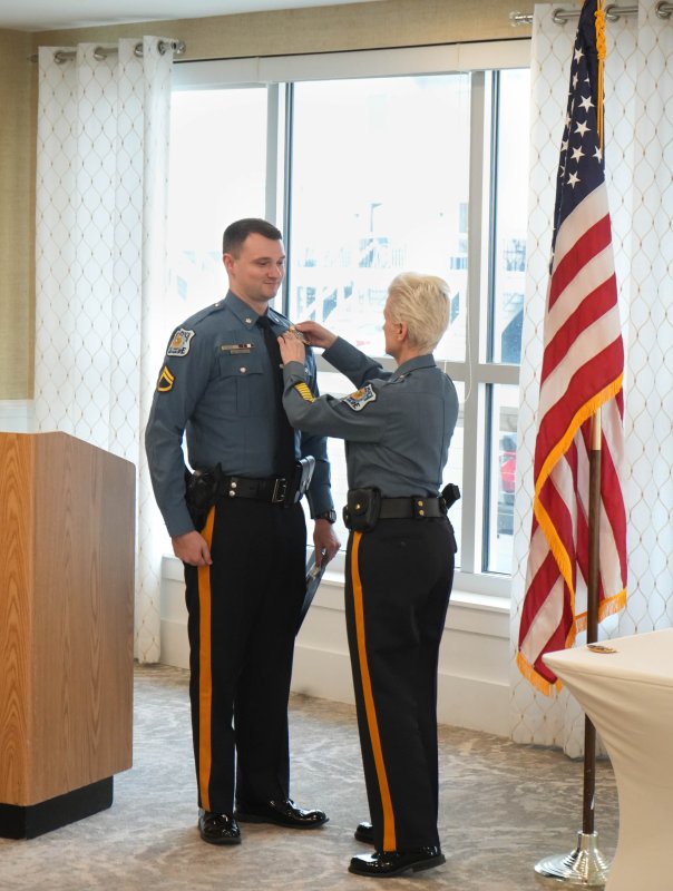 Sgt. Gavin Vaughn, left, receives a new badge from Chief Constance Speake as he is promoted from the rank of staff corporal.